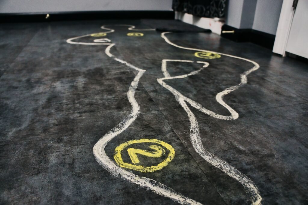 Image of the Crime Scene escape room at Escape This Frederick MD. It shows a crime scene outline of a body with numbers depicting clues.