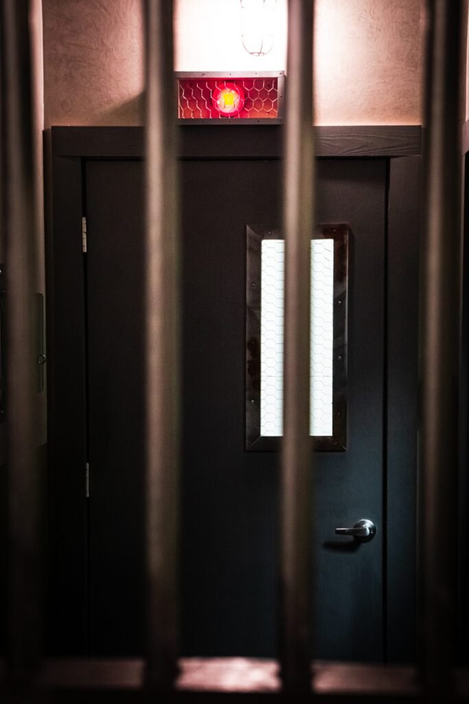 Image of the Cell Block 1 exit door from inside the prison bars.