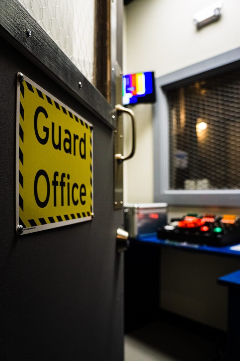 An Image of the Cell Block 1 escape room Frederick MD. Looking into the guard's office through the door with the office blurry in the background.